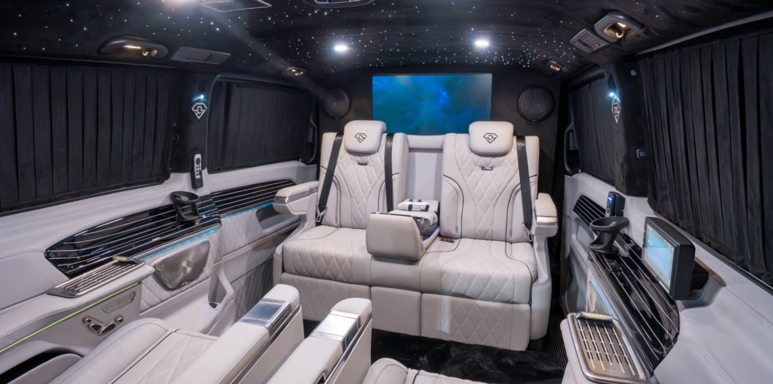 Wide view of the Land Jet cabin with star-lit ceiling, rear bench and entertainment screen