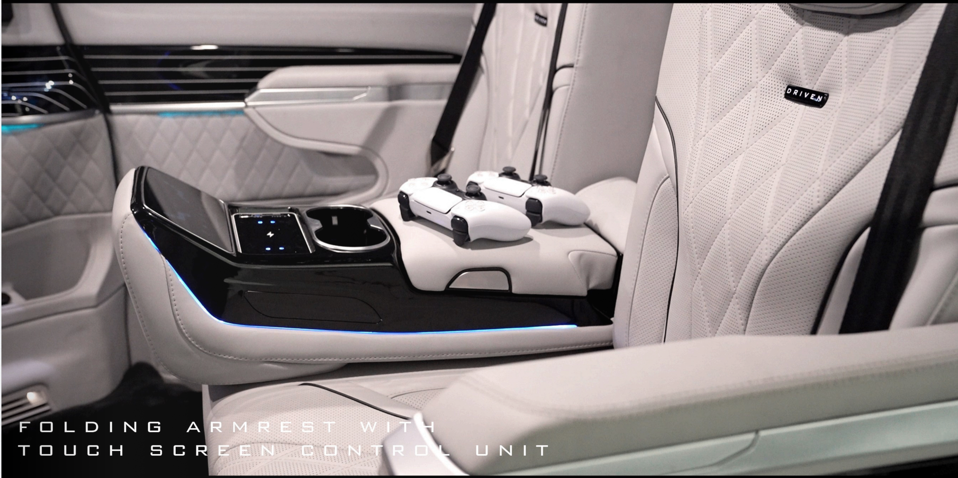 Folding armrest with touch screen control unit and PlayStation controllers on the rear bench